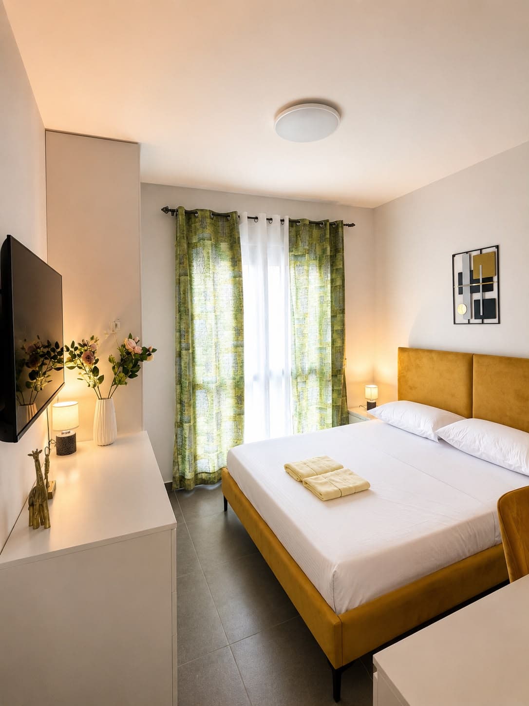 Bedroom with TV and green curtains