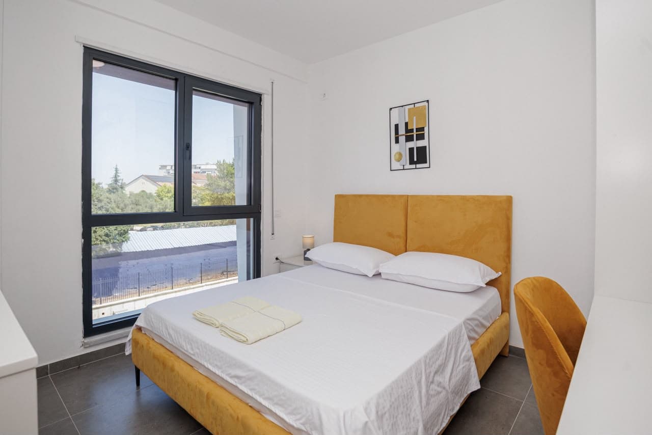 Bedroom with large window and golden headboard