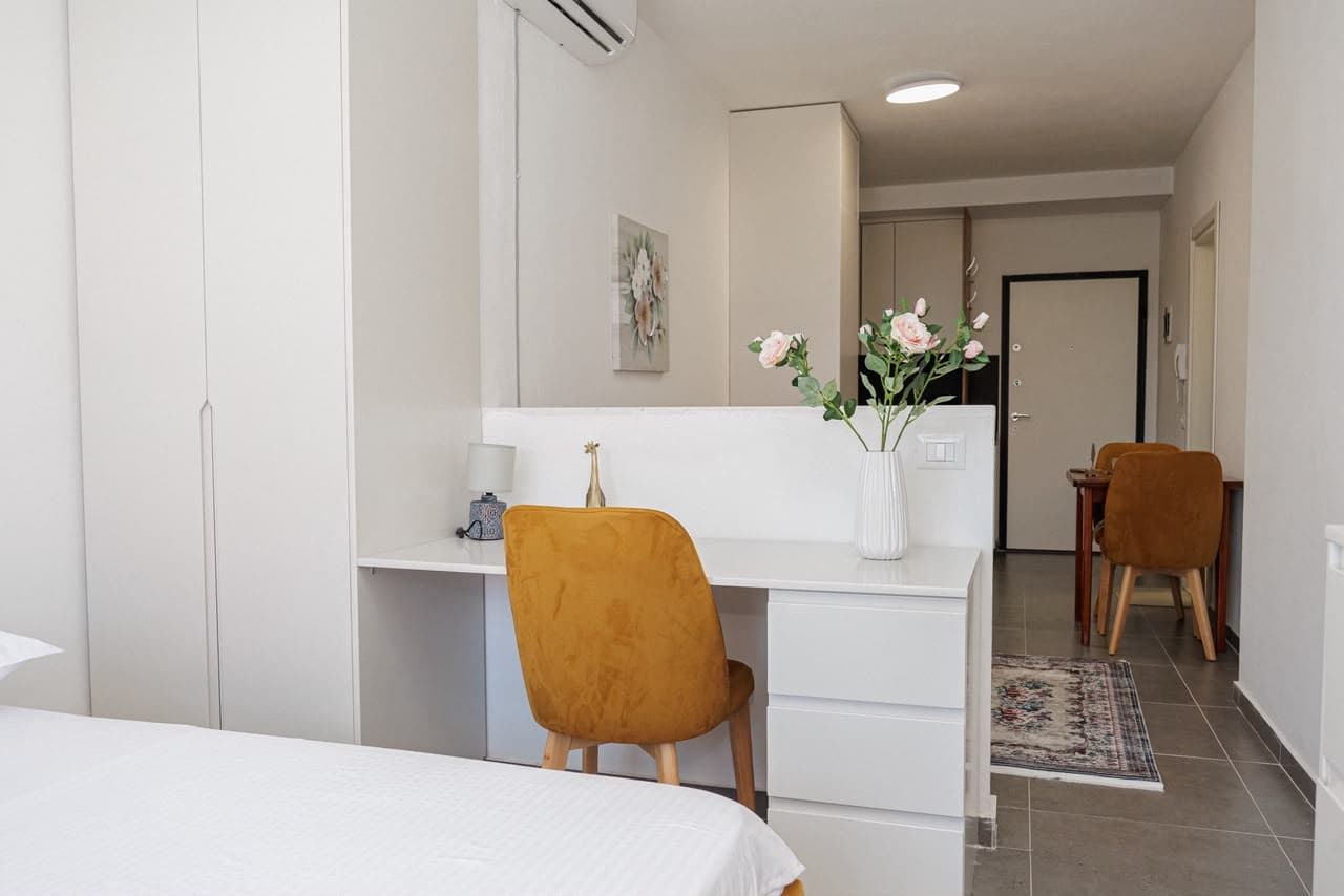 Bed, desk and dining area in the open-plan apartment