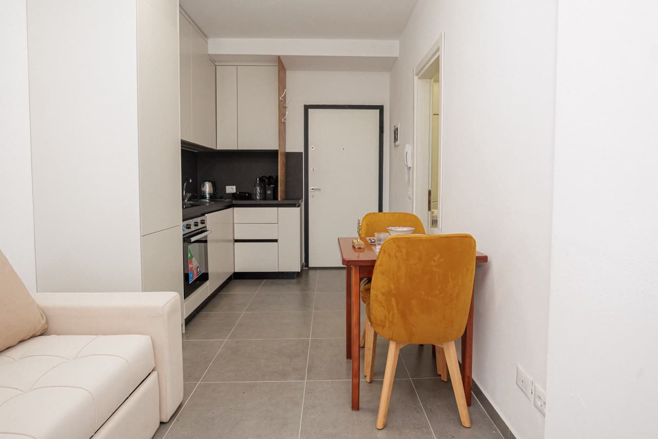 Living area with sofa, dining table and kitchen