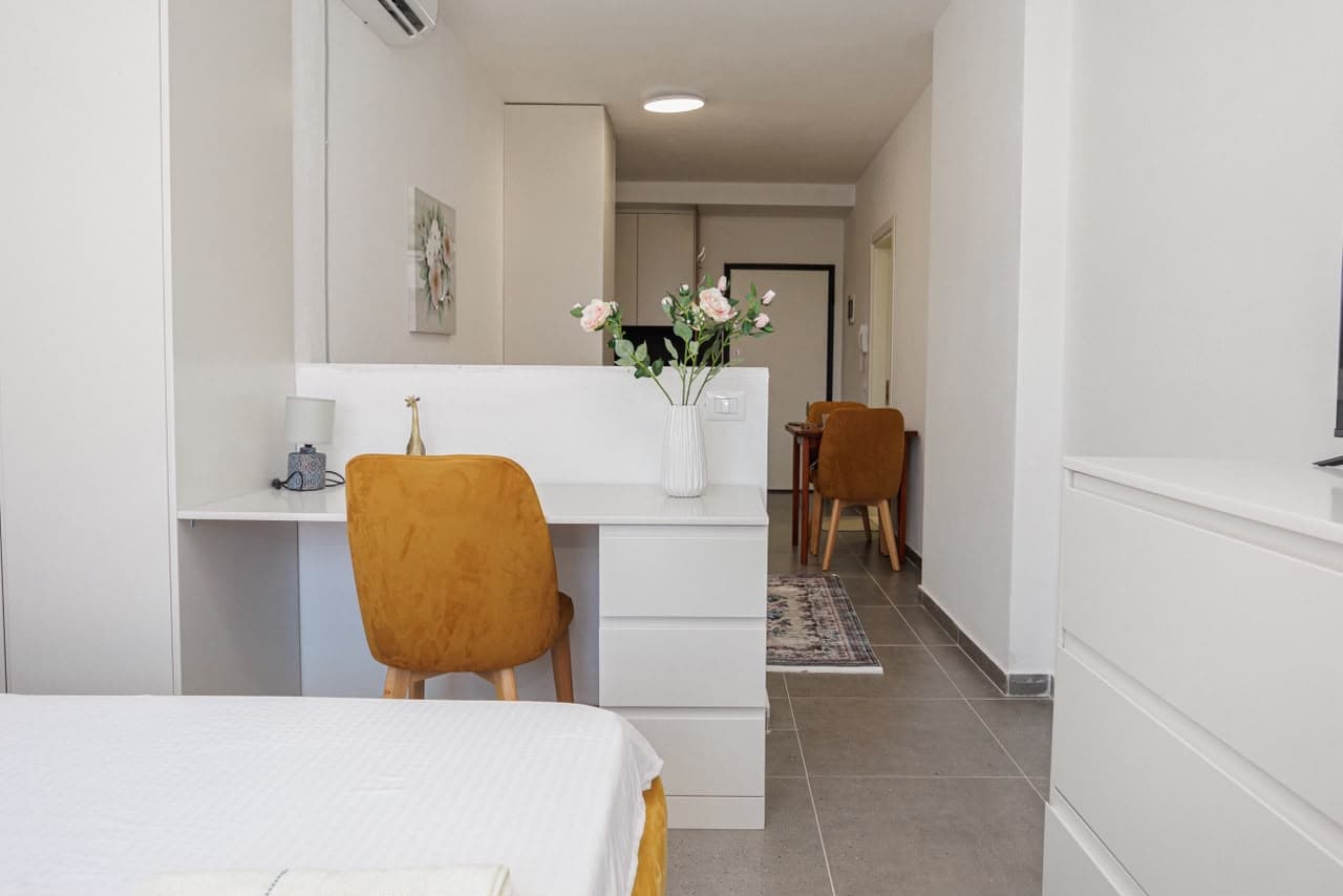 Open-plan living area with desk and bed